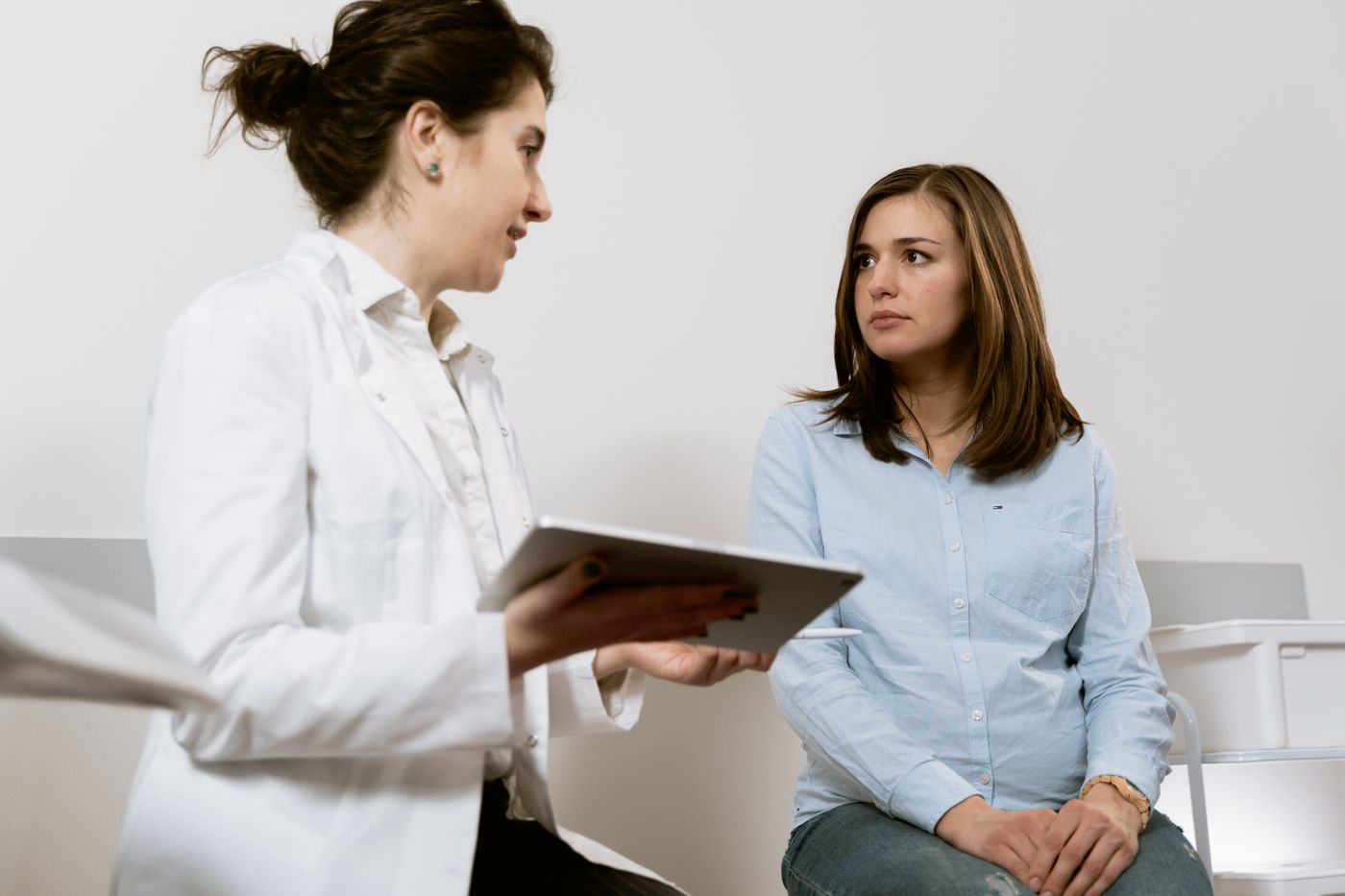Médecin consultant un patient avec une tablette en cabinet