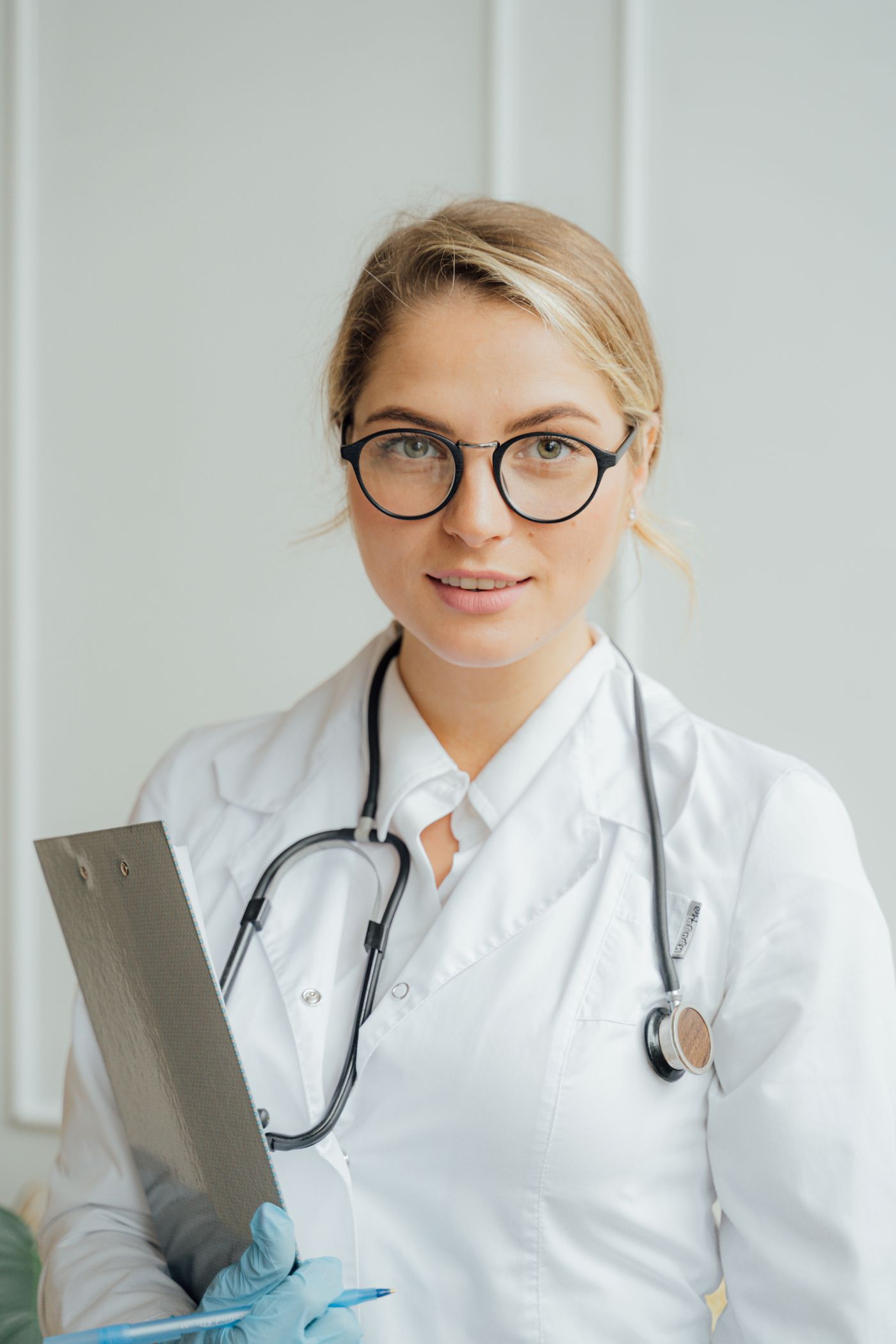 Médecin en blouse blanche tenant un dossier patient dans un cabinet médical