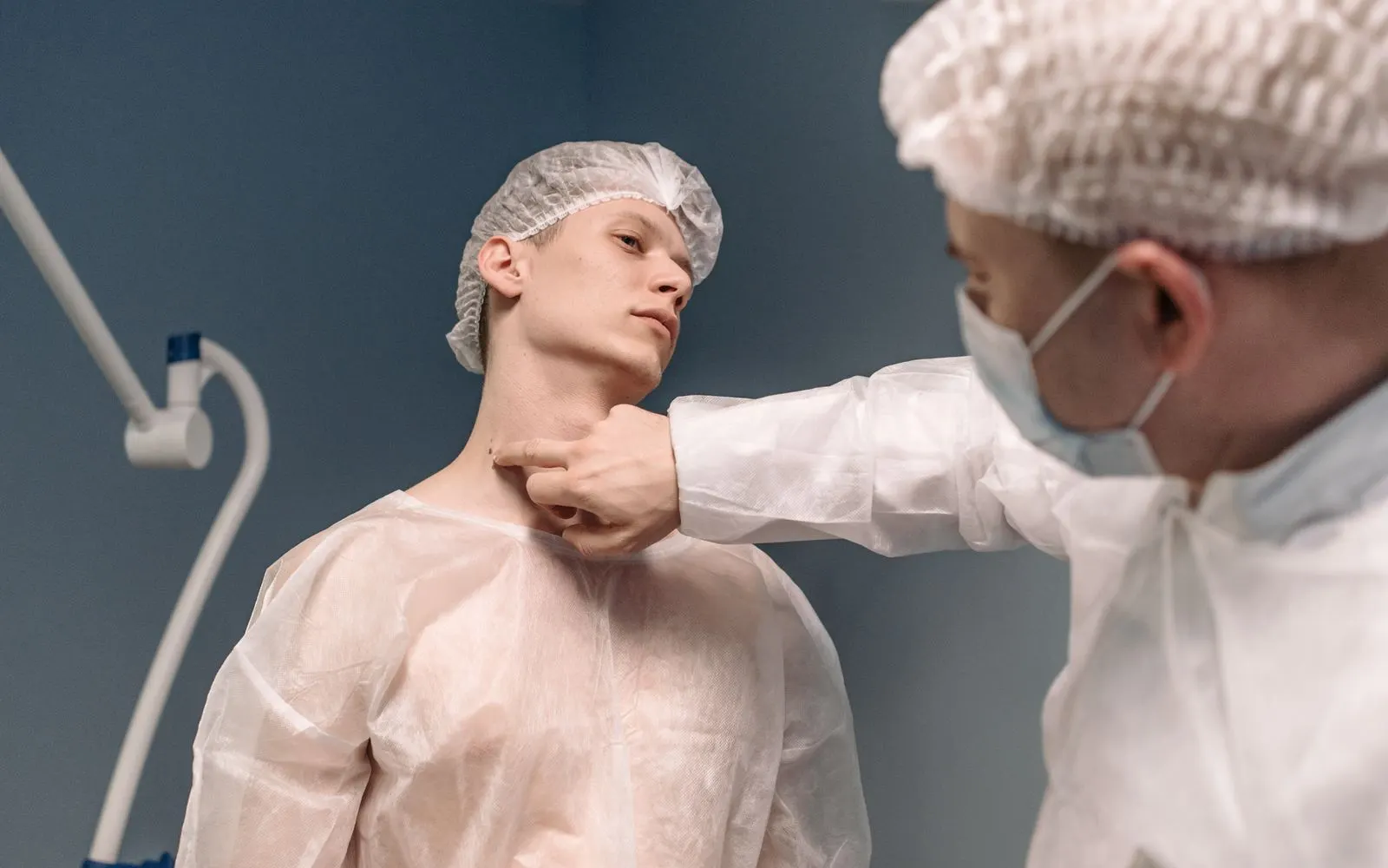 Médecin palpant le cou d'un patient pour examiner la thyroïde