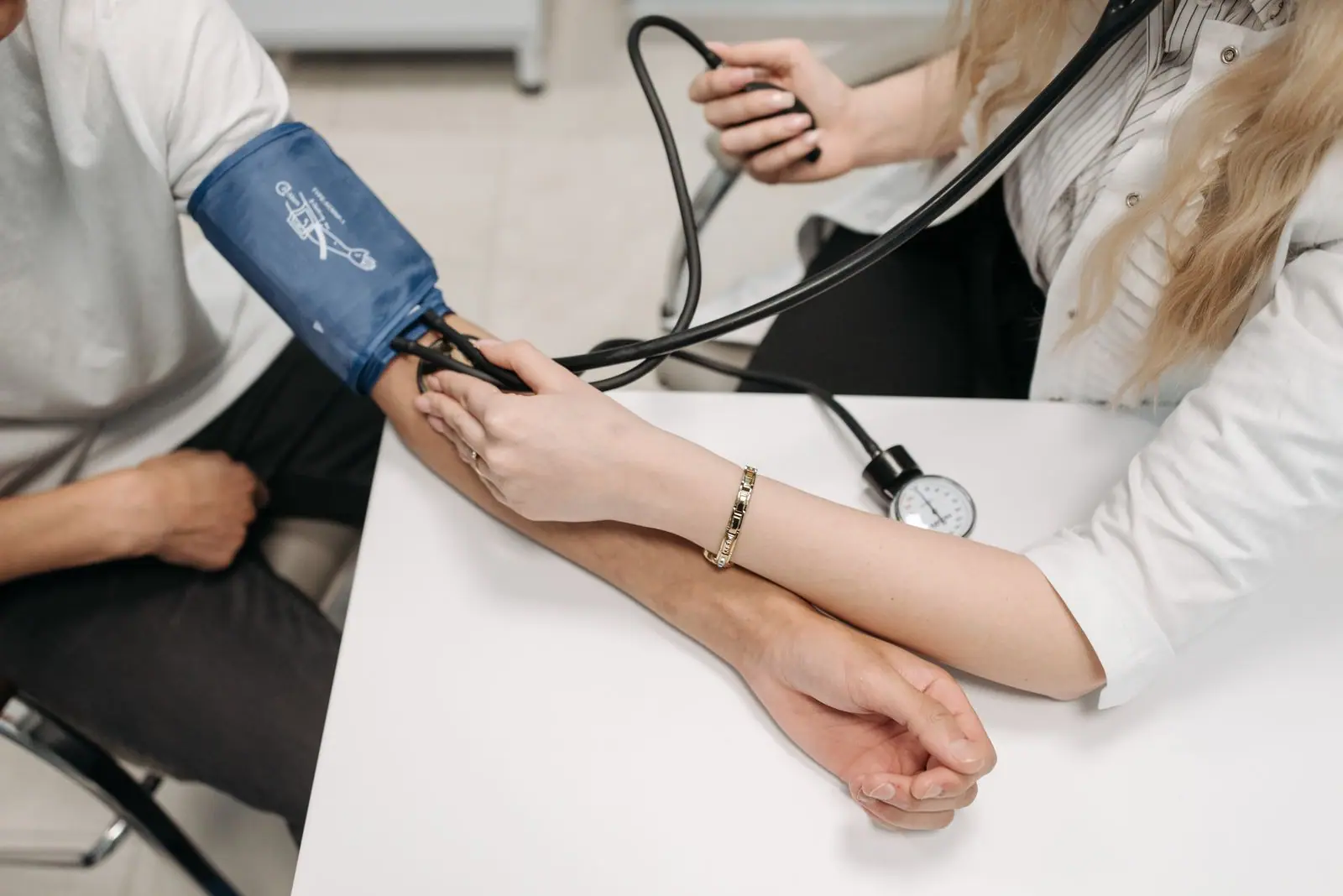 Médecin mesurant la tension artérielle d'un patient en consultation
